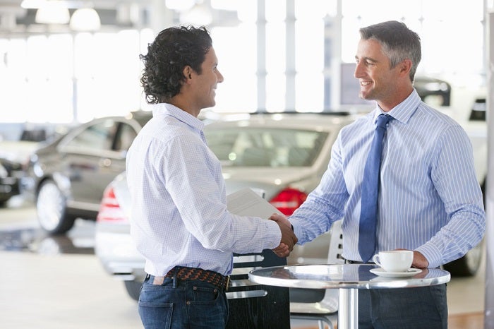 Image of a shopped shaking hands with a car salesman.