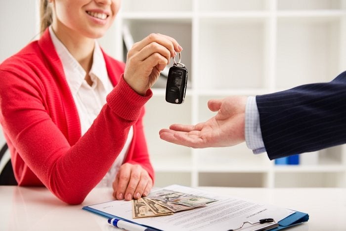 Image of a finance staff handing a customer car keys.
