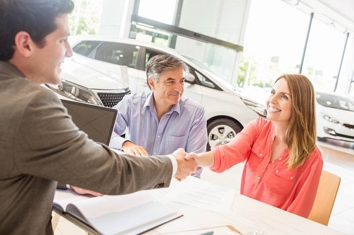 Image of a couple sitting at a table talking with a salesperson.