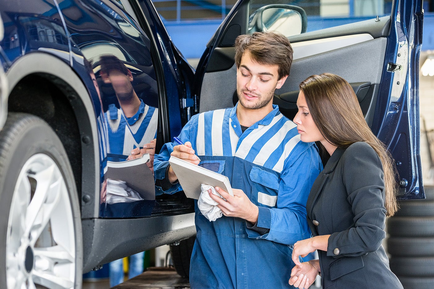 Image of a young woman and a mechanic shaking hands
